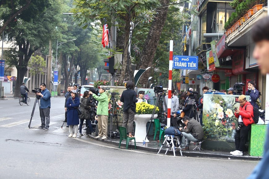 Des reporters internationaux attendent au carrefour des rues de Ngô Quyên et Trang Tiên, près de l’hôtel Sofitel Legend Metropole Hanoi.