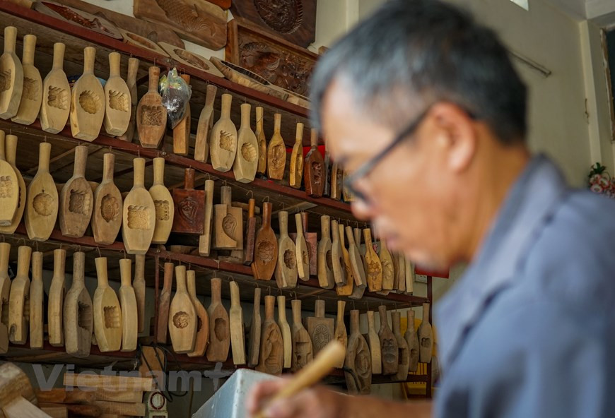 Sa dextérité augmente proportionnellement aux callosités qui se forment sur la paume de ses mains. Ses créations sont plus fines, plus belles, avec des motifs toujours plus complexes. Sa clientèle est séduite. M. Ban raconte qu’il y a une dizaine d’années, à chaque automne, l’atelier familial fonctionnait à plein régime du fait de nombreuses commandes provenant du Nord au Sud, et même de l’étranger. "Nous produisions environ 500 à 600 pièces, chacune vendue entre 150.000 et 300.000 dôngs, en fonction de sa taille. Le prix des grands moules pouvait monter jusqu’à un million de dôngs. Il y a des années où grands-parents, parents, enfants et petits-enfants se mobilisaient pour répondre aux commandes à temps". Photo: Vietnamplus