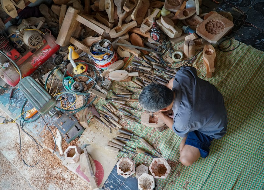 Tous les habitants du village de Thuong Cung, commune de Tiên Phong, district de Thuong Tin, à Hanoi, connaissent Trân Van Ban, l’un des derniers artisans fabriquant de moules à gâteaux de lune. Après s’être renseigné et avoir longé quelques chemins vicinaux, l’on tombe rapidement nez à nez avec sa maison. Trân Van Ban est menuisier. «J’ai commencé à apprendre la menuiserie très jeune. Auparavant, je travaillais pour la coopérative locale et étais payé en riz. J’arrivais à l’époque à gagner quelques dizaines de kilos par mois. Puis est arrivée la période de +vaches maigres+. Je n’ai pas eu d’autre choix que de quitter la coopérative pour fonder mon propre atelier», a raconté l’artisan. Photo: Vietnamplus