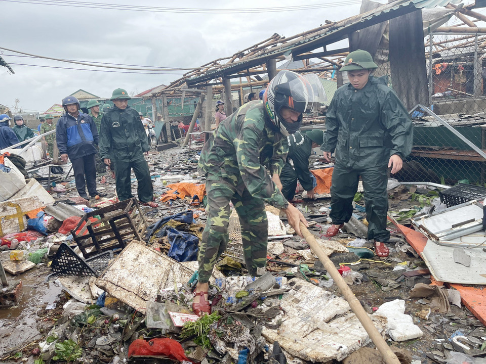 Des gardes-frontières participent au nettoyage d'un marché dans le bourg de Cua Viet après le passage du typhon Noru. Photo: VNA