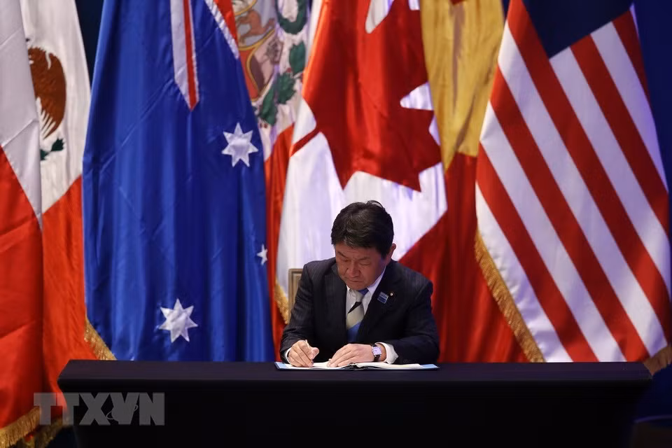 Le ministre japonais de l'Économie Toshimitsu Motegi signe le CPTPP. 