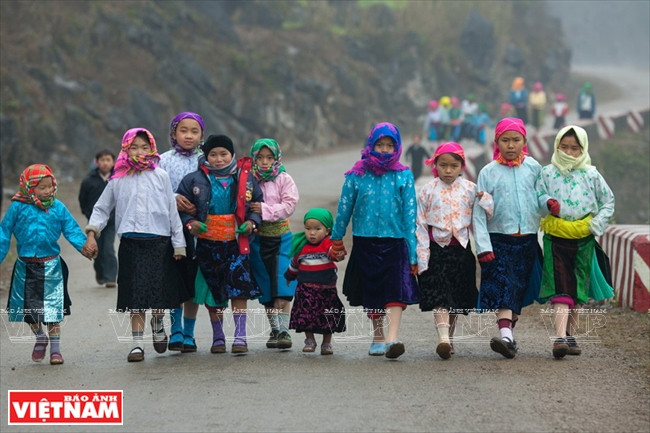 Des enfants H’mông dans leurs nouveaux costumes traditionnels font une promenade sur le col de Ma Pi Leng pendant les vacances du Têt.