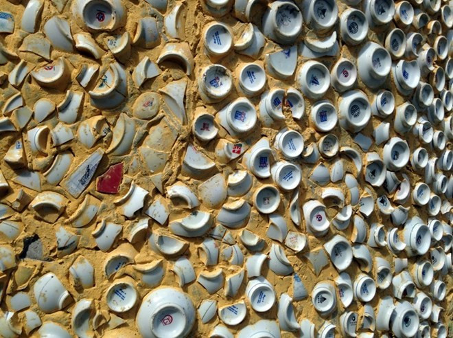 Partie d’un mur du sanctuaire principal couvert de bols, d’assiettes et de fragments de faïence.