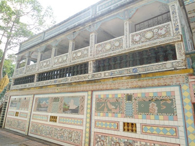 Façade d’un mur du sanctuaire principal revêtue de bols et d’assiettes de toutes couleurs.