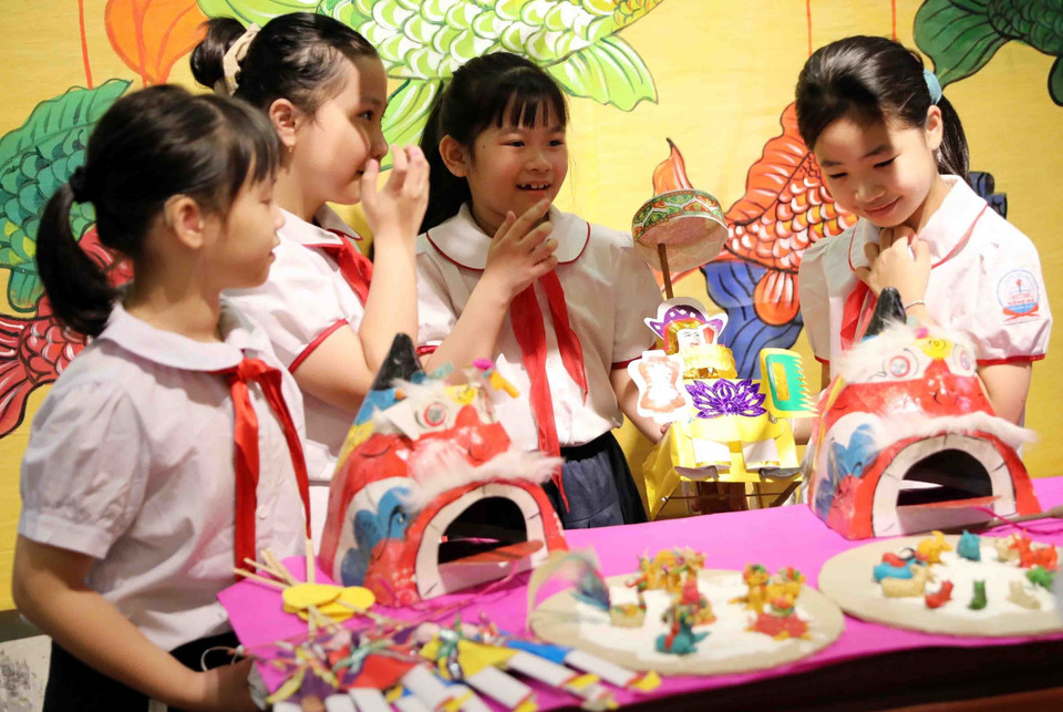 Des élèves sont ravis de découvrir des jouets traditionnels de la mi-automne. Photo : VNA