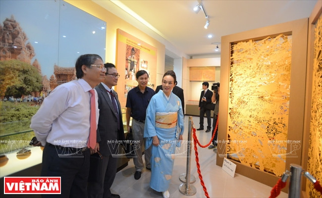 Toba Mika présente ses œuvres au vice-président du Comité populaire municipal de Da Nang, Nguyen Ngoc Tuan (chemise blanche), et au consul général du Japon à Ho Chi Minh-Ville, Kawaue Junichi (veste).