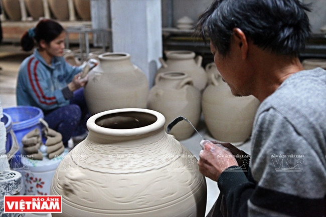 Modelage des motifs sur une jarre d’alcool de riz 