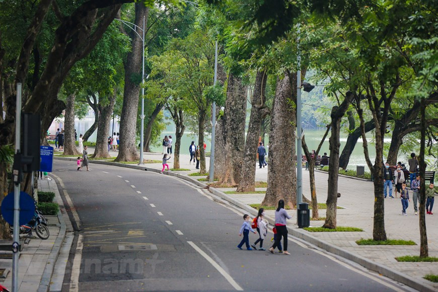 Le bus traverse le lac de Hoan Kiem. Ce lac est considéré comme le bijou de Hanoï, tout comme la tour Eiffel pour Paris. Il est non seulement un site incontournable pour les visiteurs, mais aussi un monument historique important de la capitale. Mais surtout, le lac Hoan Kiem constitue l’image affective que chacun des Hanoïens tient au cœur. Il n’est pas un lac de grande largeur, ni de grand profondeur: sa profondeur moyenne est d’environ 1,2m. S’étalant sur une superficie de 12ha, le lac HoanKiem se situe au cœur de l’arrondissement de Hoan Kiem, qui est nommé après lui. Il relie les deux quartiers: le vieux quartier et celui de l’architecture française. Photo:Vietnam+ 