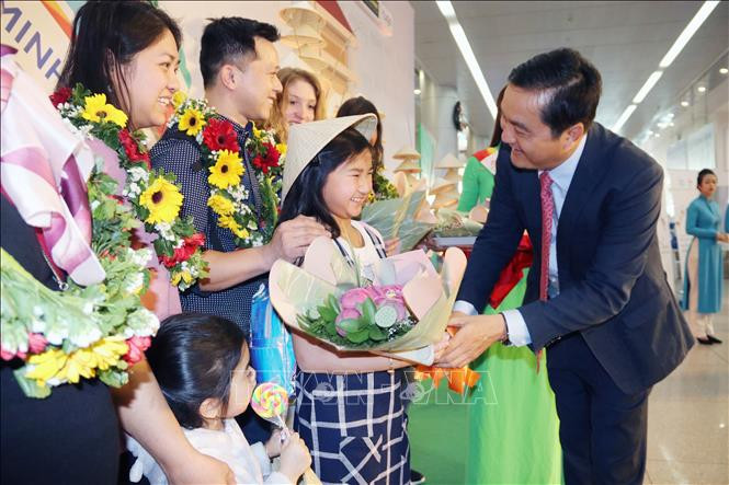 Le directeur du Service municipal du tourisme offre des fleurs aux premiers touristes étrangers de l'année 2020.