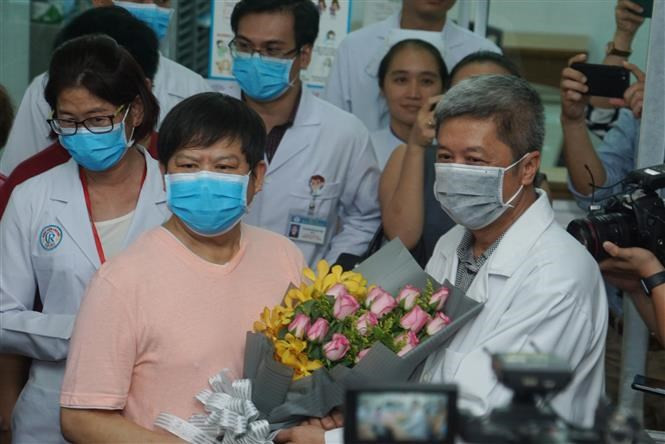 Le vice-ministre vietnamien de la Santé Nguyen Truong Son (droite) offre un bouquet à Li Ding pour saluer son rétablissement.