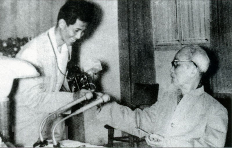 Le Président Hô Chi Minh offre des cigarettes parfumées au journaliste Lam Hong Long - l'auteur d'une célèbre photo "Bác bắt nhịp Bài ca Kết đoàn" (L'Oncle Hô bat la mesure de la chanson de solidarité). 