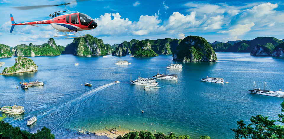 Découvrir la baie de Ha Long en hélicoptère et en croisière. Principale attraction touristique, la baie d'Ha Long (Quang Ninh) a la beauté enchanteresse des pics calcaires entourés d'eaux bleues. Avec plus de 2000 îles, il existe de nombreux sites magnifiques à explorer. Photo: Vnexpress