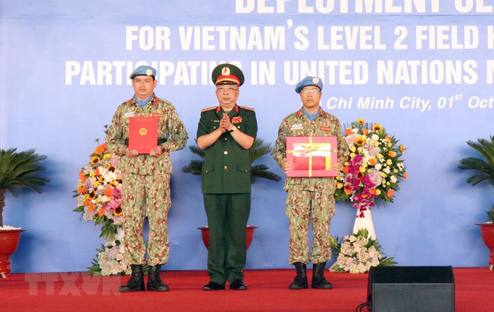  Le général de corps d’armée Nguyen Chi Vinh, vice-ministre de la Défense, remet le drapeau national et la décision du président sur l’envoi de l’hôpital de campagne de niveau 2 No.1 participant à la Mission de maintien de la paix de l’ONU au Soudan du Sud.