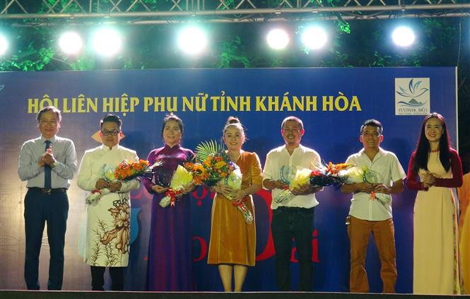  Le vice-président du Comité populaire de la province de Khanh Hoa, président du comité d'organisation du festival de la mer de Nha Trang - Khanh Hoa 2019 a offert des fleurs aux stylistes et sponsors du festival de l’ao dài. Photo : VNA