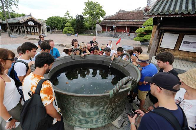  Des touristes visitent des urnes de bronze – trésor national, implantées dans la citadelle. Photo : VNA
