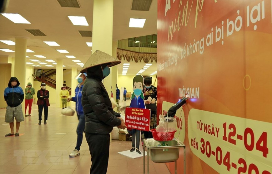 Des personnes défavorisée reçoivent le riz à partir d'un ATM installé à la commune de Phuc Diên, district de Bac Tu Liêm à Hanoi. Photo: VNA