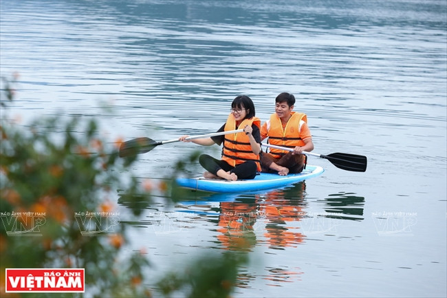 Des visiteurs peuvent découvrir le lac Hoa Binh en kayak 