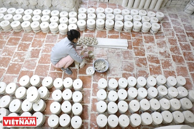 L’argile blanche résistante au feu, matériau utilisé pour fabriquer les cochons-tirelires est soigneusement mélangé avec l'eau pour devenir lisse, puis coulé dans des moules