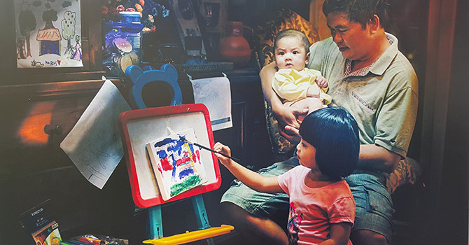 Un père enseigne à son enfant à dessiner.