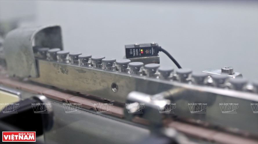 Les flacons après avoir été remplis de vaccin sont immédiatement bouchés. Photo: Vietnam Illustré