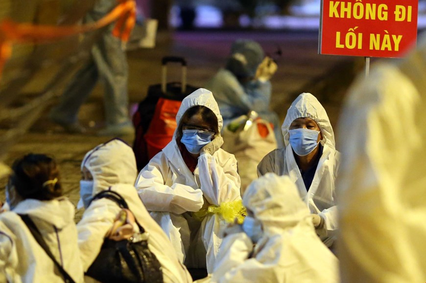 Des patients infectés par le COVID-19 emmenés à l'hôpital de campagne pendant la nuit attendent leur tour pour s'enregistrer. Photo: VNA