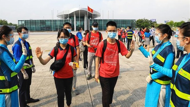 Le personnel de l'aéroport de Noi Bai à Hanoï accueille des étudiants de l'Université de Médecine de Hanoï qui partent pour la province méridionale de Binh Duong afin de soutenir sa lutte contre le COVID-19. Photo: VNA