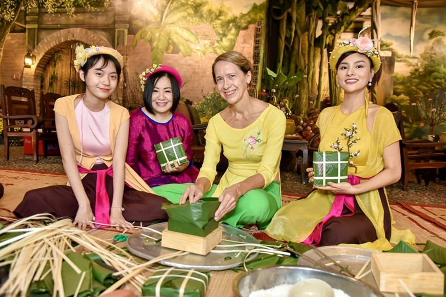 Des amis internationaux aiment confectionner le “banh chung”. Contrairement à la restauration rapide des temps modernes, la confection du Banh chung exige des étapes compliquées et fastidieuses, à partir de la préparation minutieuse et rigoureuse des ingrédients et des épices jusqu’à la cuisson soignée pendant plusieurs heures. Pour faire un bon banh chung qui se conserve environ un mois, on doit choisir le riz gluant parfumé et fibreux. Le gâteau au centre duquel se trouvent du porc et des haricots mungo est enveloppé en forme de carré dans des feuilles de dong (phrynium placentarium) qui donneront au riz une couleur verte après environ 8 à 10 heures de cuisson. Photo: Vietnam+