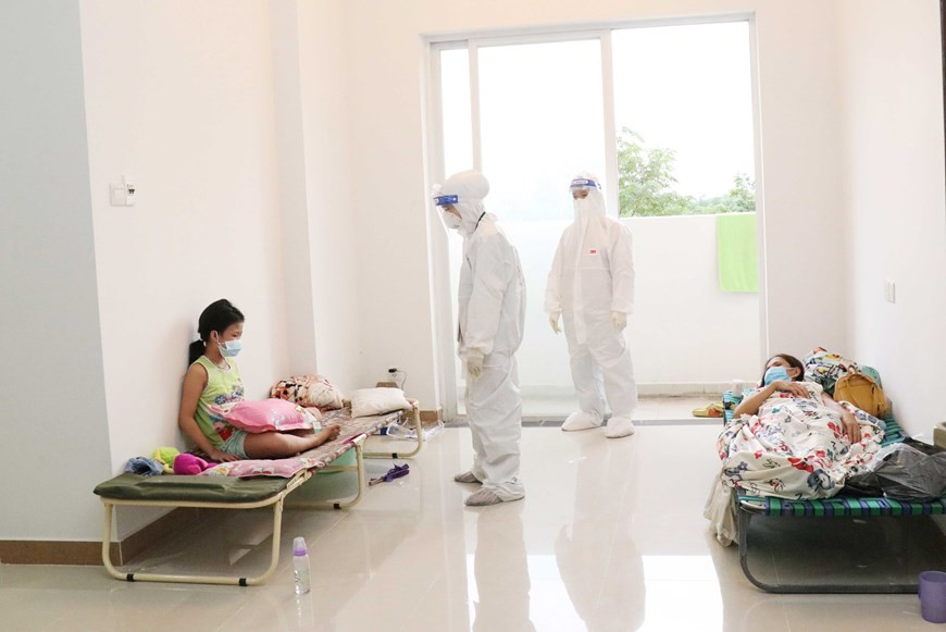 Le personnel médical s'enquiert de la santé d'une patiente. Photo: VNA