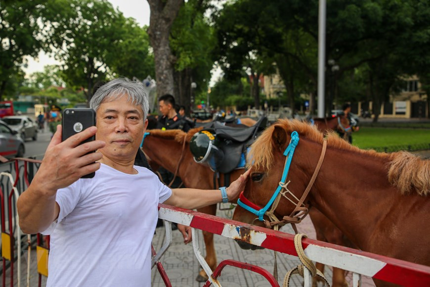 Dès la bonne matinée du 8 juin, un grand nombre d'habitants de la capitale étaient présents dans le lieu où l'équipe de Police mobile à cheval se préparait pour son défilé pour prendre des photos avec la cavalerie. Le colonel Nguyen Huy Hanh, chef de la force de police, a déclaré que celle-ci avait activement conseillé au commandement de la Police mobile pour organiser des entraînements dans le but de participer au défilé ainsi qu'à l'accueil des dirigeants du Parti et de l'État venant à cet événement. Les forces de sécurité publique sont chargées de la lutte contre la criminalité, tandis que les garde-frontières et les douanes sont responsables de la prévention du trafic de drogue dans les zones frontalières et les ports. Donc, ils ne doivent pas s'acquitter de cette tâche pour séparé, a –t-il noté. Photo : Minh Son/VietnamPlus 