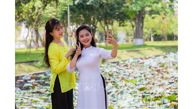 Les touristes captent de beaux moments avec les fleurs de lotus dans la terre natale de l'Oncle Hô.
