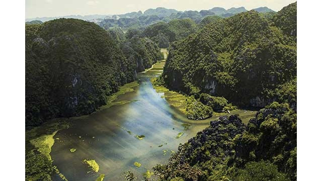 La rivière Hoàng Long est une grande rivière et l'une des quatre voies navigables nationales de la province de Ninh Binh. La rivière est prise à partir de la confluence entre la rivière Bôi et la rivière Lang de Kênh Gà au pont Gian Khâu. La section appelée rivière Hoàng Long fait environ 25 km de longue, étant située dans la zone de dérivation des crues du bassin de Nho Quan. Le bassin de la rivière Hoàng Long couvre la moitié du Nord de Ninh Binh, dont Nho Quan, Gia Viên et Hoa Lu, et la ville de Ninh Binh. Tam Côc, Ninh Binh, vu de la montagne de Ma Yên. Photo : Dan Rochelle.