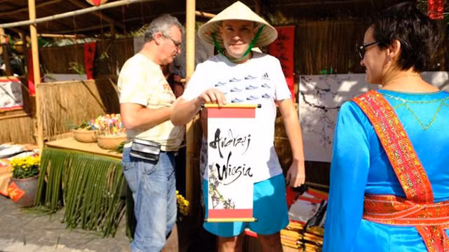 Les visiteurs demandent des calligraphies et participent aux jeux populaires du Têt traditionnel du Vietnam.