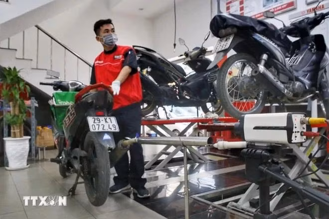 Un technicien vérifie les émissions des motos dans un centre d'entretien de motos. Photo : VNA