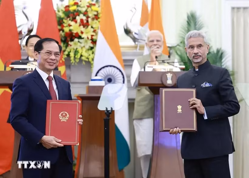 Les responsables des ministères des Affaires étrangères du Vietnam et de l’Inde s’échangent l'accord entre les deux gouvernements permettant aux proches des membres des missions diplomatiques et des consulats de travailler contre rémunération. Photo : VNA