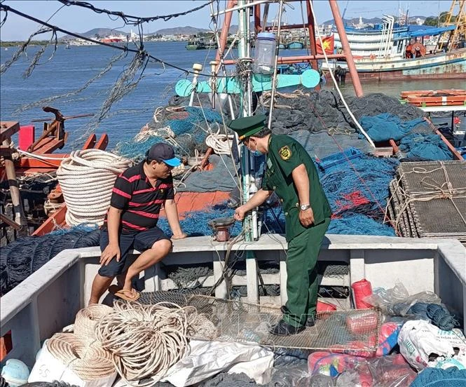 Un garde-frontières du port de Vung Tàu inspecte l’équipement de surveillance par satellite installé sur un bateau de pêche au port de Cat Lo. Photo : VNA