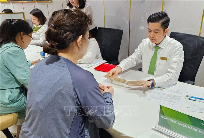 Des clients achetant des lingots d’or à Vietcombank à Hô Chi Minh-Ville. Photo : VNA
