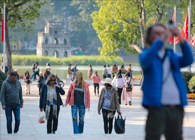 Touristes se promenant au bord du lac Hoàn Kiêm (Epée restitué), à Hanoi. Photo: VNA