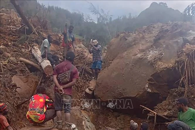 Des personnes fouillent les débris sur le site d’un glissement de terrain, dans la province d’Enga, en Papouasie-Nouvelle-Guinée, le 26 mai. Photo : VNA