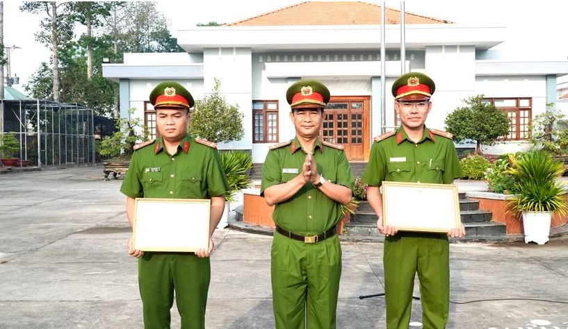 Pham Thanh Tâm, directeur adjoint du Département provincial de la sécurité publique de Long An remet les certificats de mérite du ministère de la Sécurité publique à deux policiers. Photo : VNA