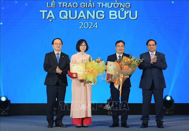 Le Premier ministre Pham Minh Chinh (1er, à droite) et le ministre des Sciences et des Technologies Huynh Thành Dat (1er, à gauche) remettent les Prix Ta Quang Buu 2024 à la Docteure Nguyên Thi Kim Thanh et au professeur associé-Docteur Trân Manh Tri. Photo : VNA