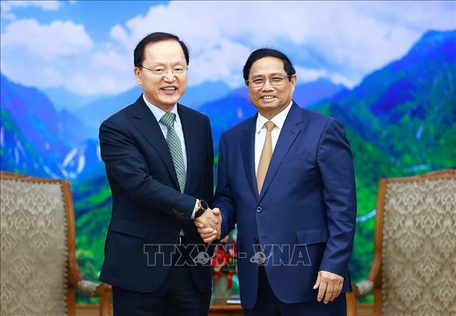 Le Premier ministre Pham Minh Chinh (à droite) serre la main du directeur financier de Samsung Electronics Park Hark-kyu, à Hanoi, le 9 mai. Photo: VNA