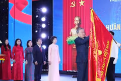 Le secrétaire général To Lam épingle l’Ordre de Hô Chi Minh sur le Drapeau traditionnel de la VNA. Photo : VNA