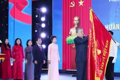 Le secrétaire général To Lam épingle l’Ordre de Hô Chi Minh sur le Drapeau traditionnel de la VNA. Photo : VNA