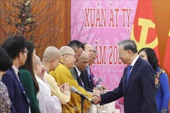 Le secrétaire général du Parti, Tô Lâm, et des Vietnamiens d'outre-mer lors de la rencontre. Photo: VNA