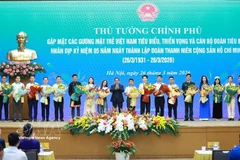 Le Premier ministre Pham Minh Chinh offre des fleurs de félicitations aux jeunes Vietnamiens exemplaires. Photo : VNA