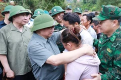Le Premier ministre Pham Minh Chinh et des sinistrés. Photo: VNA