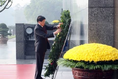 Le secrétaire général du PPRL et président lao Thongloun Sisoulith, rend hommage au Président Hô Chi Minh en son mausolée. Photo: VNA