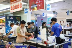 Des clients règlent leurs achats au supermarché Co.op Mart situé sur l'autoroute de Hanoï, dans le quartier de Tang Nhon Phu, à Hô Chi Minh-Ville. Photo : VNA