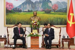 Le ministre Luong Tam Quang (gauche) et Bounthong Chitmani, membre du Bureau politique, permanent du Secrétariat et vice-président du Laos. Photo: VNA