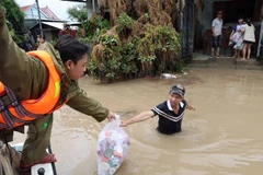 Fournir de la nourriture aux personnes dans les zones inondées le long de la rivière Banh Lai. Photo: VNA